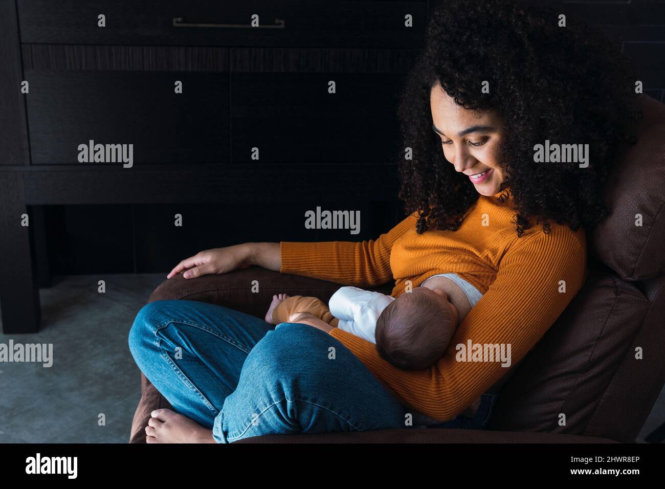 Smiling mother breastfeeding baby boy at home Stock Photo Alamy
