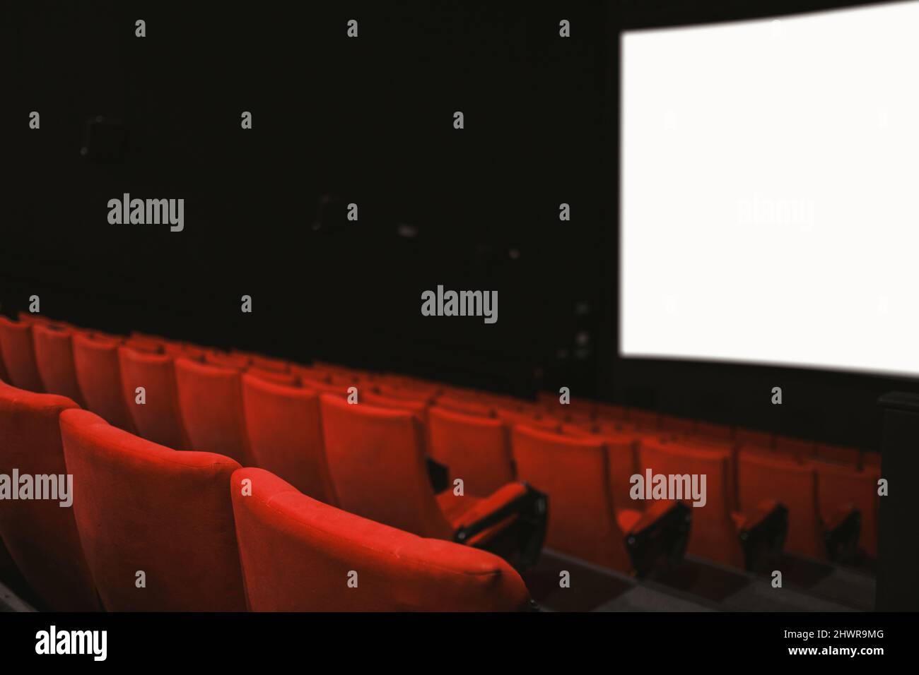 Movie theatre with empty armchairs and empty movie screen. Stock Photo