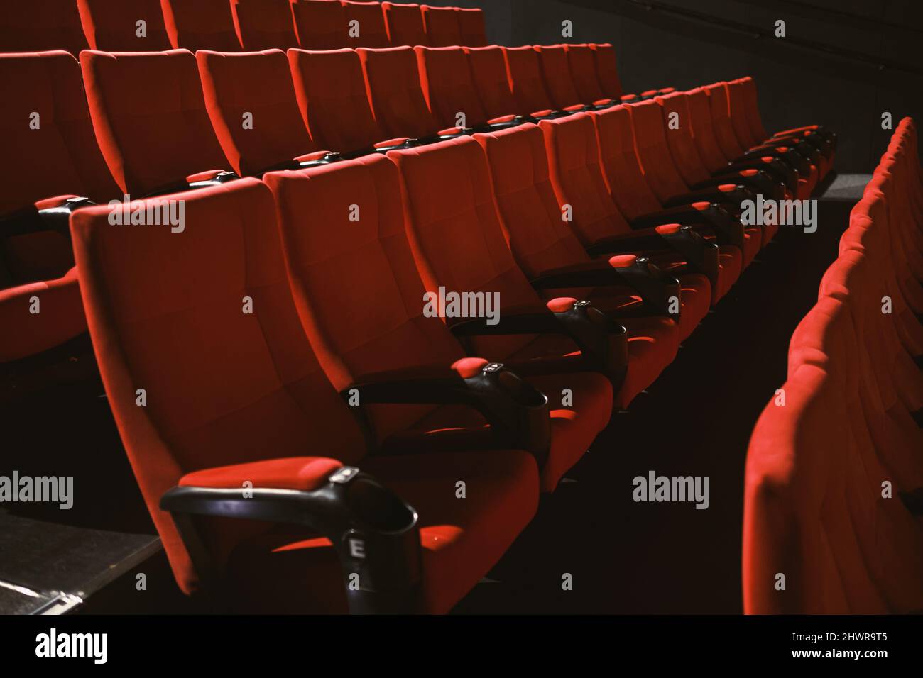 Red colored cinema seats with no people. Stock Photo