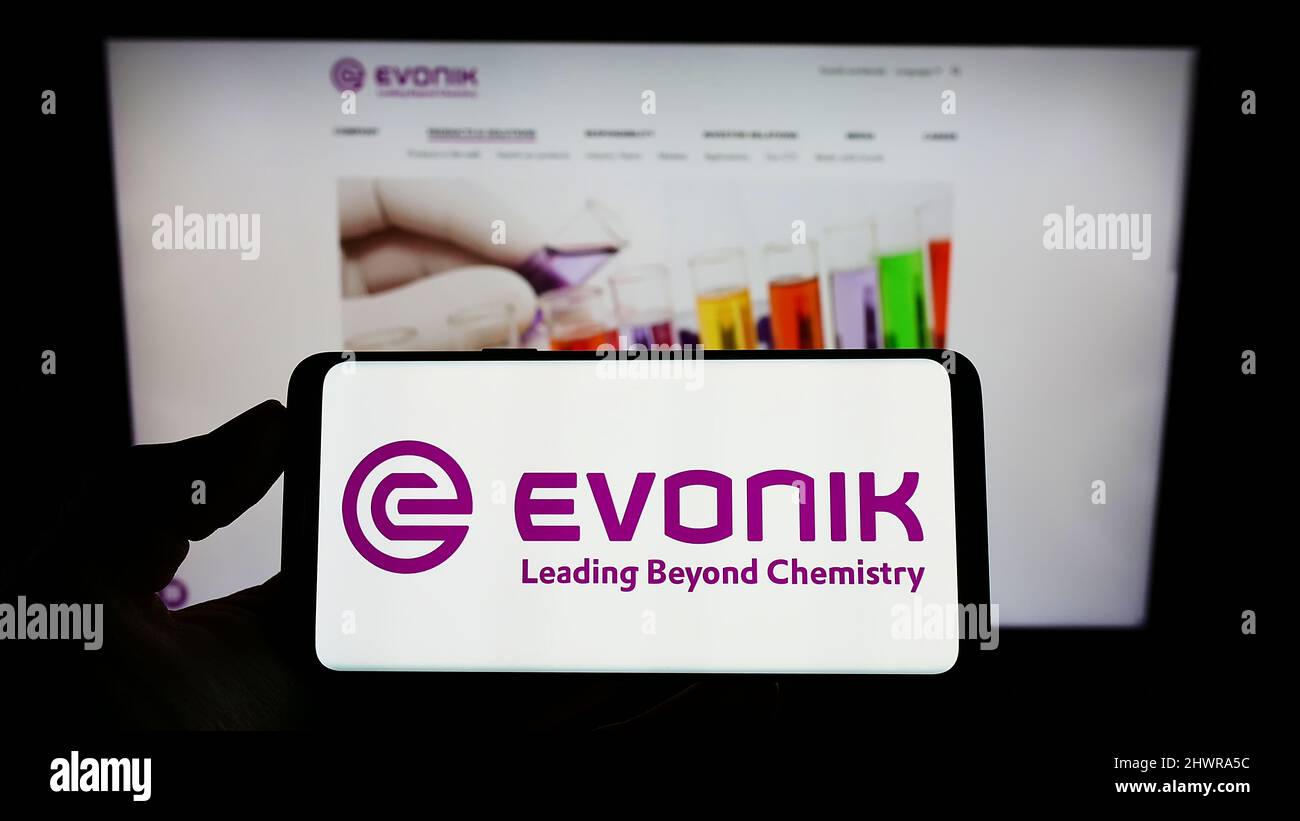 Person holding cellphone with logo of German chemicals company Evonik