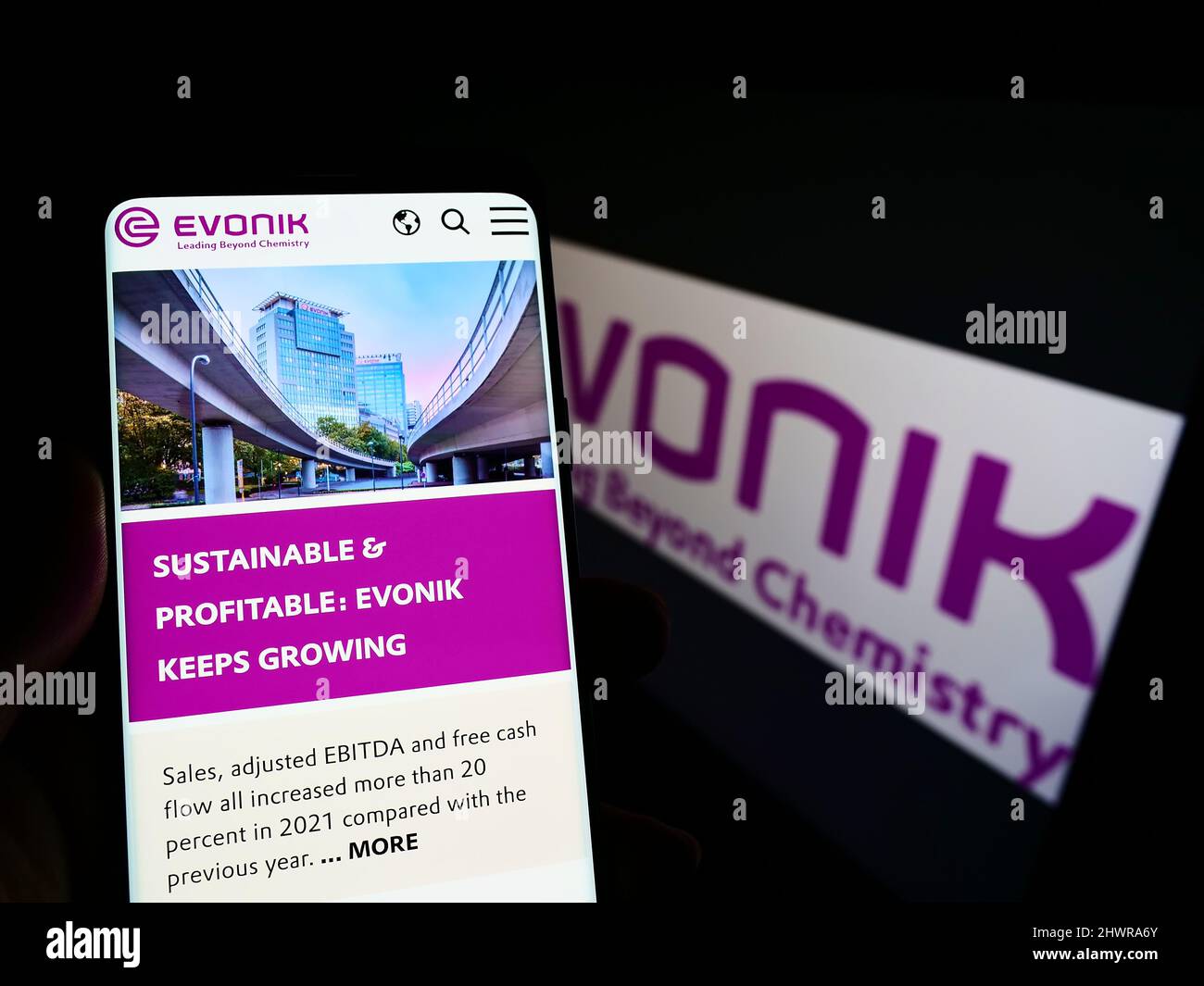 Person holding mobile phone with webpage of German chemicals company