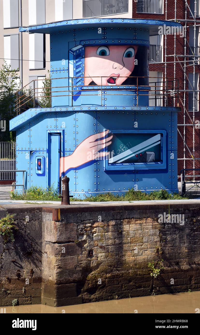 The control tower, of riveted steel, at the entrance to the Bordeaux floating harbour, now redundant & painted with a cartoon of a face trapped inside Stock Photo