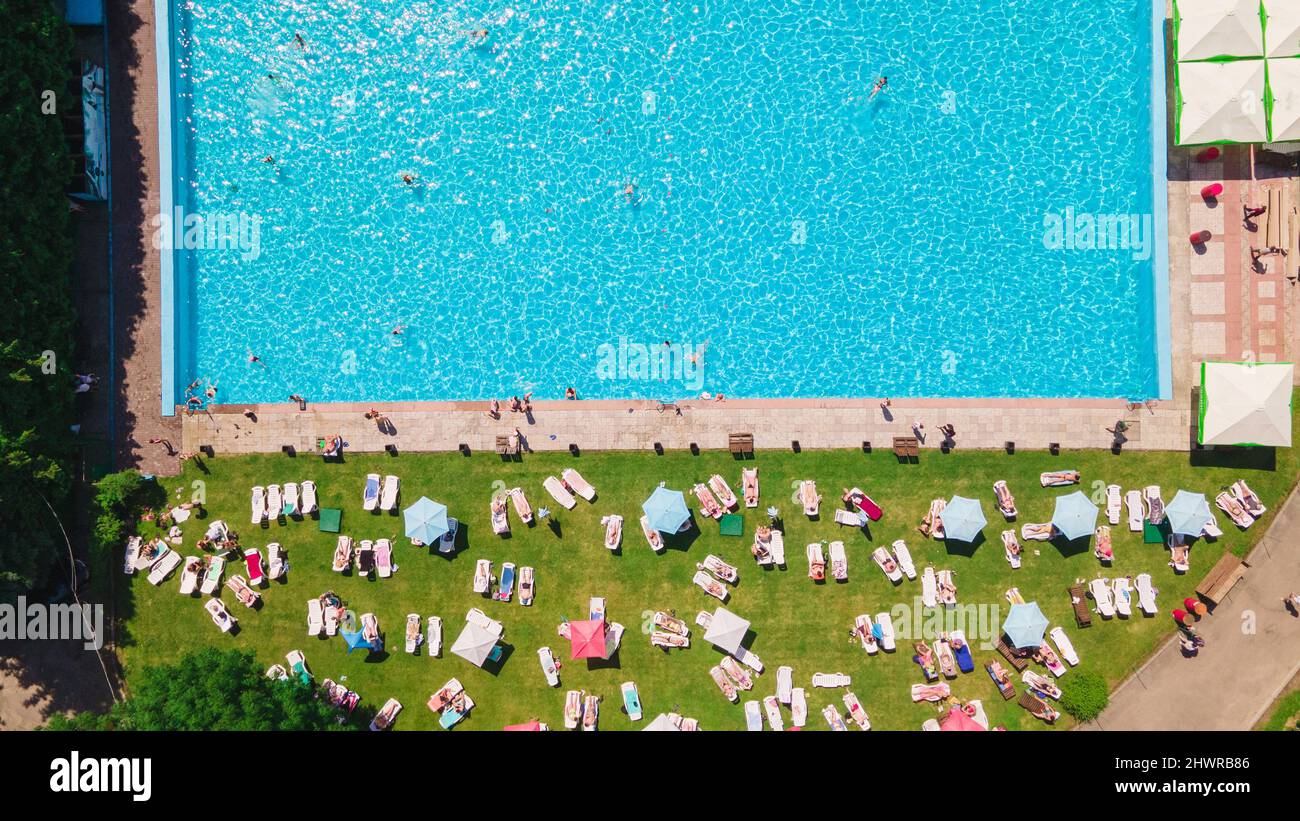 aerial view of people resting sunbathing near city pool outdoors summer