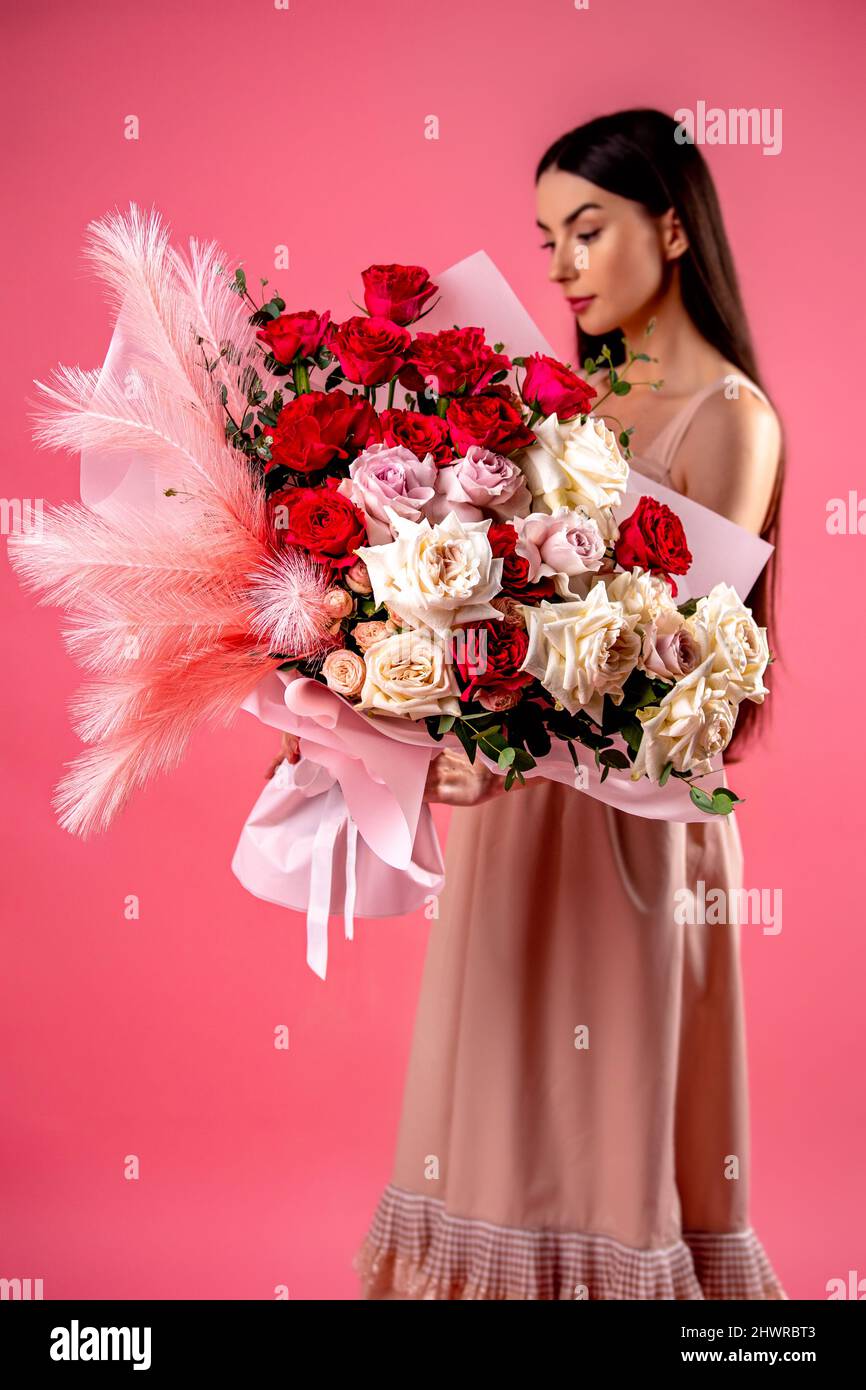 Girl holds a big bouquet of pink and white flowers. Stock Photo