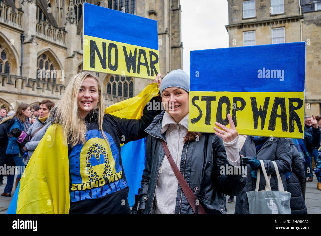 Protestors hold up stop the war placards as they listen to speeches in front of Bath Abbey during a demonstration against Russia's invasion of Ukraine Stock Photo