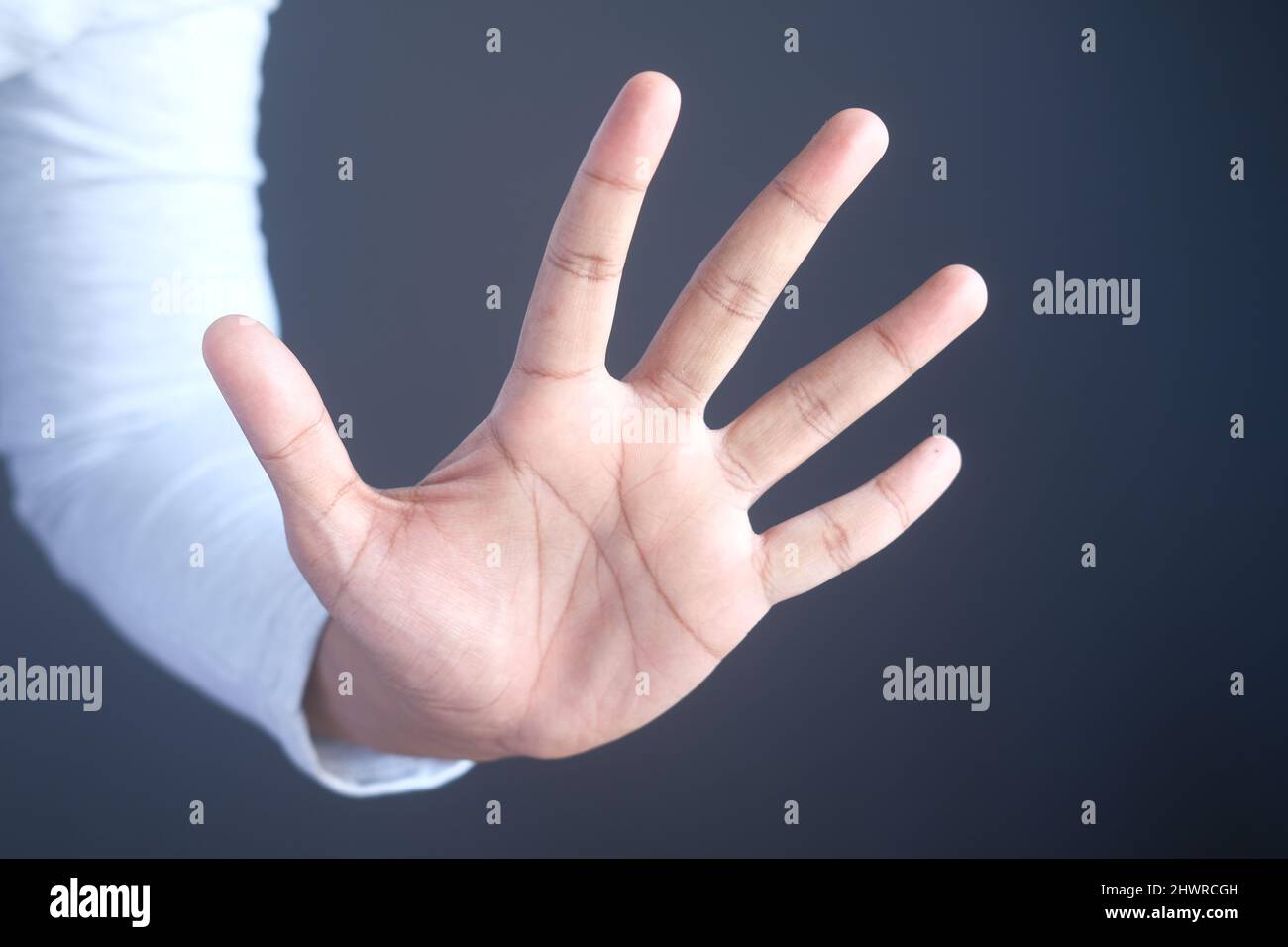 young man show stop sigh isolated in black  Stock Photo