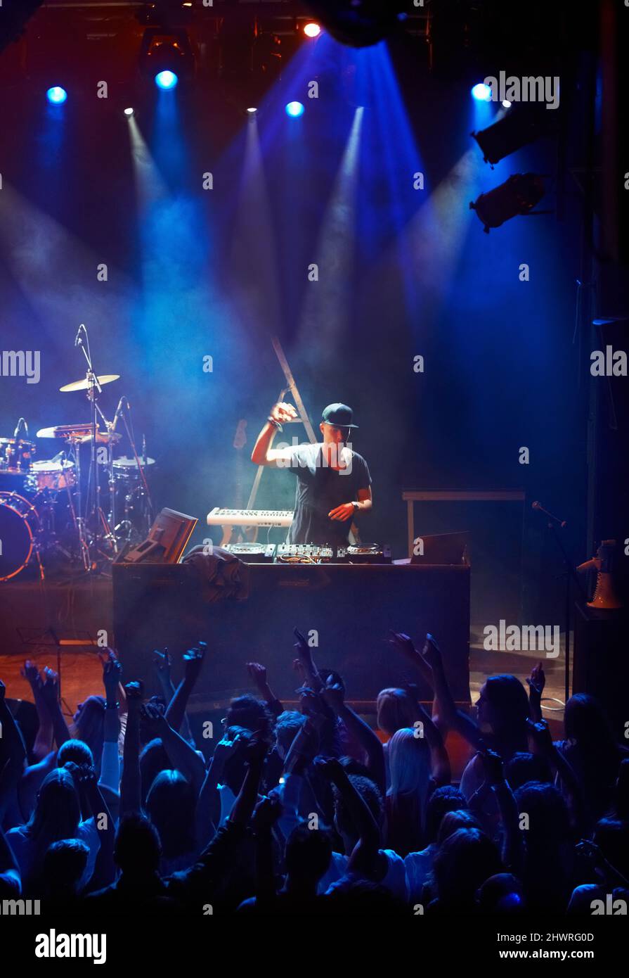 A DJ playing his live set to a group of screaming fans. This concert