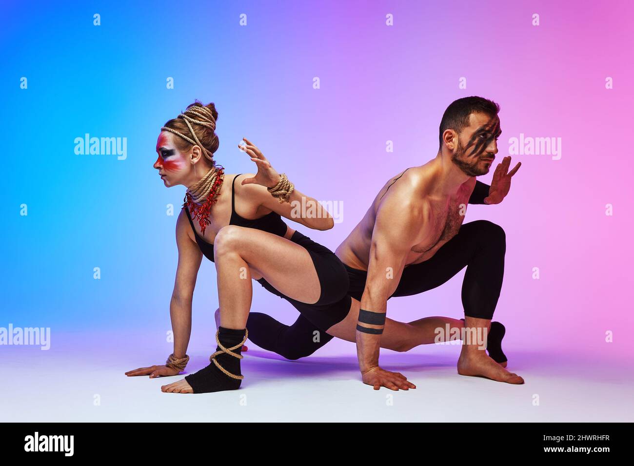 Beautiful young acrobats or gymnasts with colorful face painting on ...