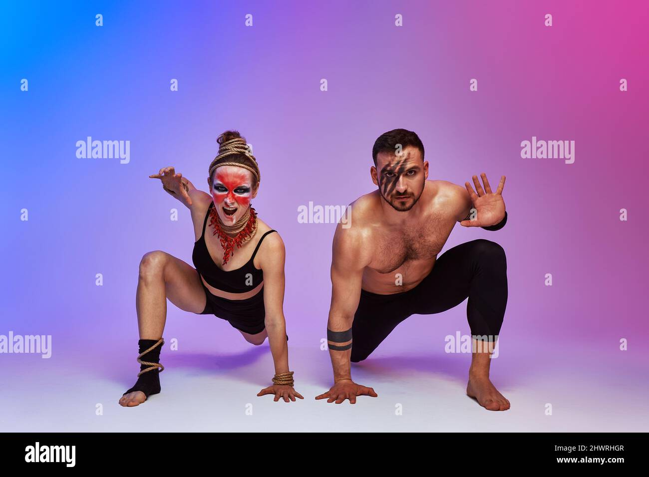 Beautiful young acrobats or gymnasts with colorful face painting on ...