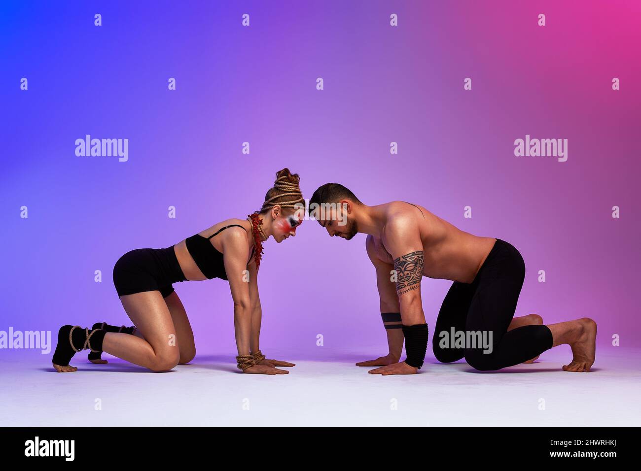 Beautiful young acrobats or gymnasts with colorful face painting on ...