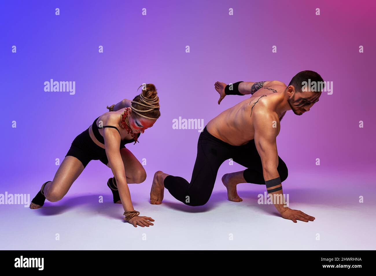 Beautiful young acrobats or gymnasts with colorful face painting on ...