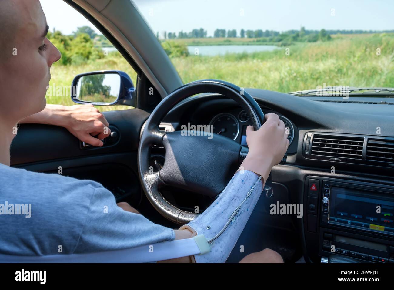 Prosthetic amputated arm of Caucasian man on the steering wheel who
