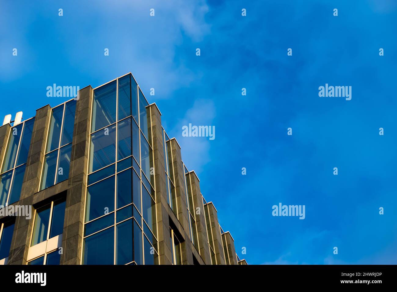 Facade of a modern apartament building against a blue sky background ...