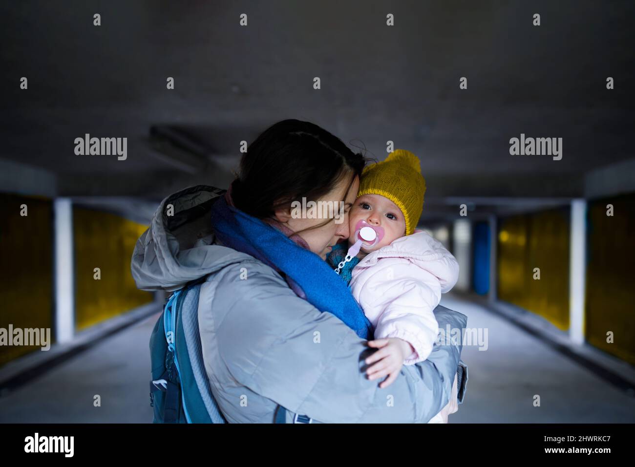 A mother holding her frightened child in the bomb shelter Stock Photo