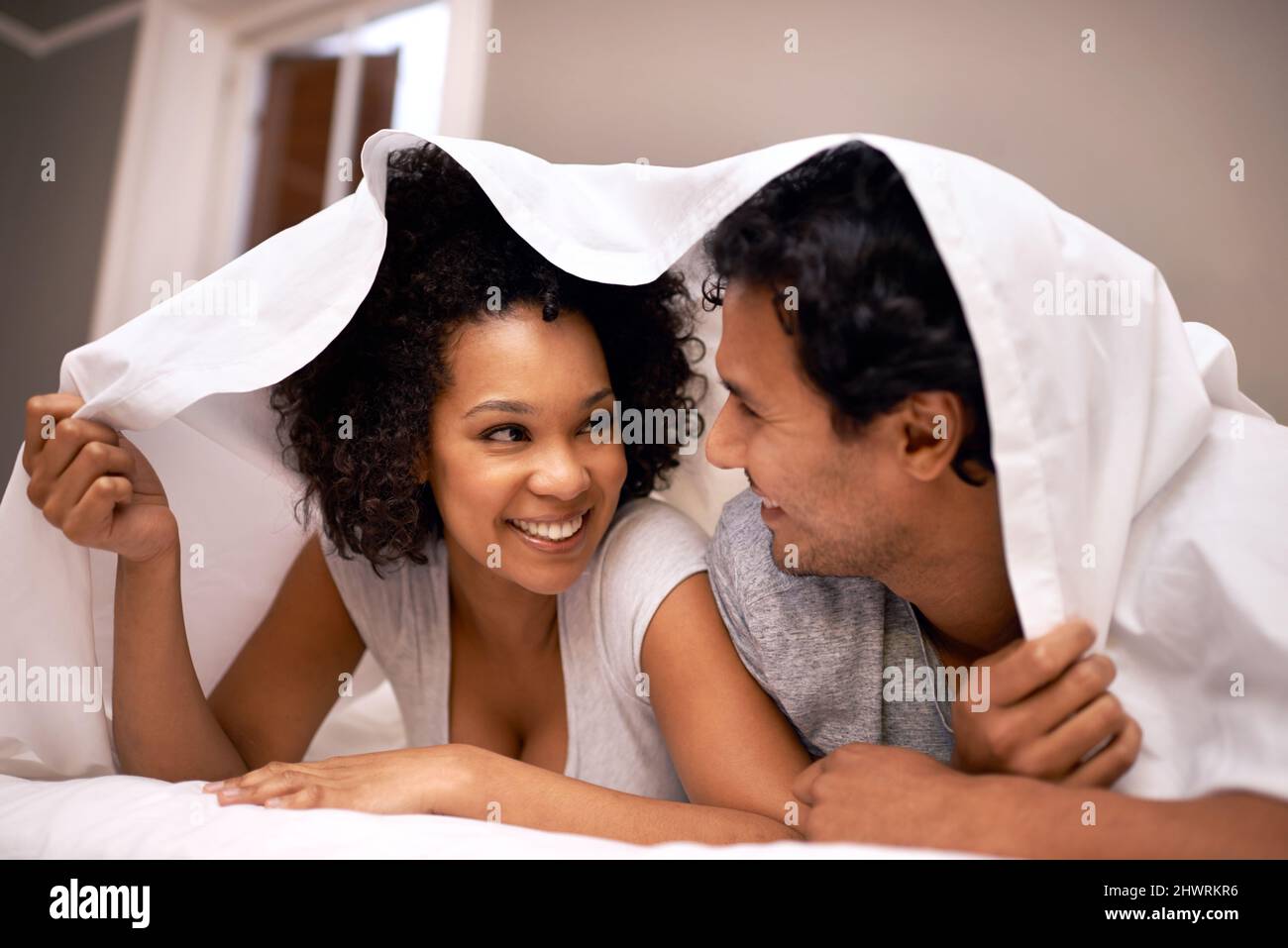 Fun under the covers. A cute couple underneath the covers Stock Photo