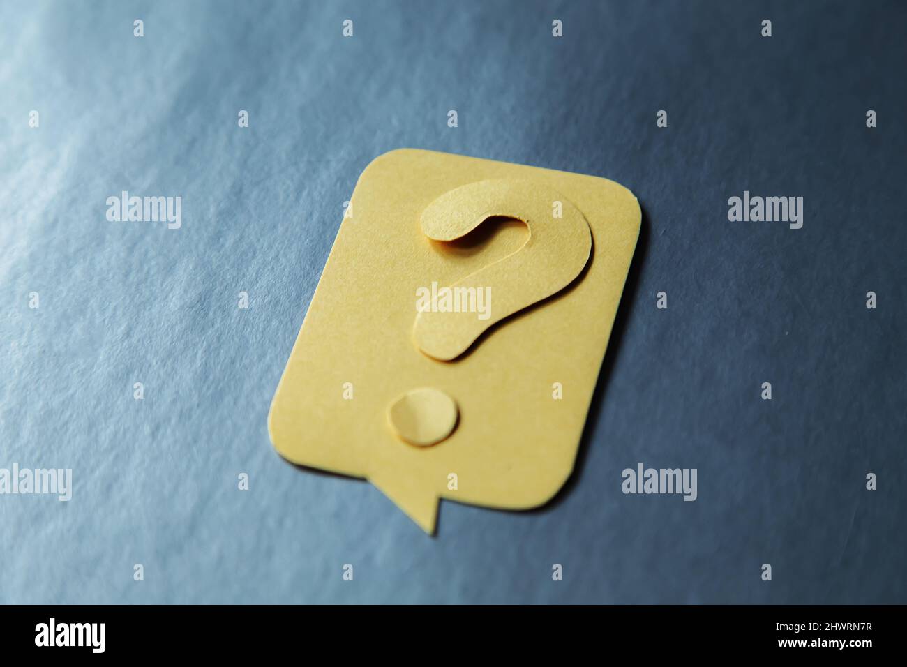 Question mark on yellow speech bubble, gray background. Problem and solution concept. Brainstorm. Stock Photo