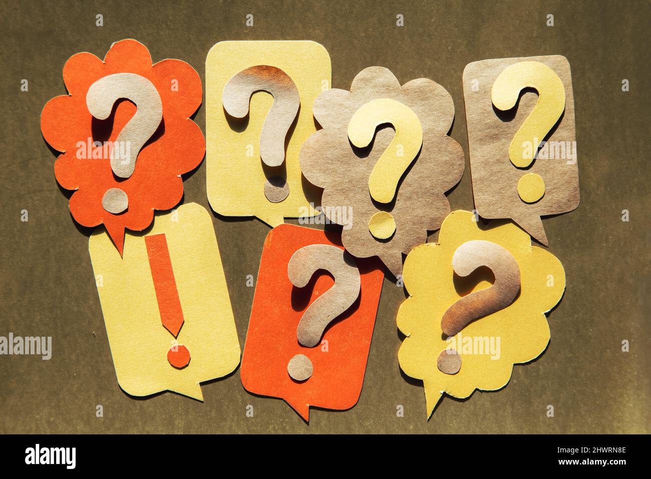 Question mark on speech bubbles, golden background. View from above. Problem and solution concept. Brainstorm. Stock Photo