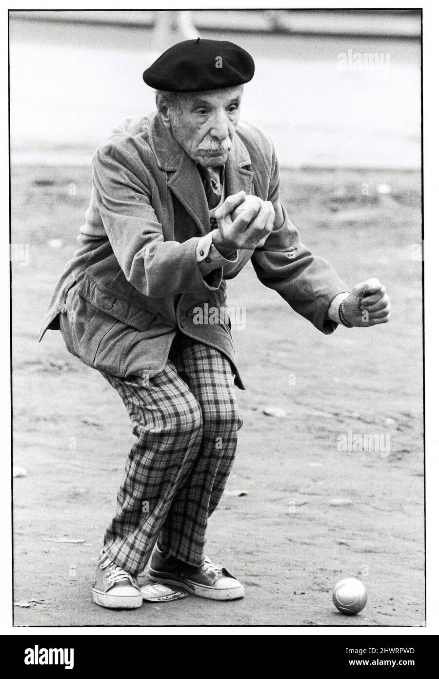 A very dapper older man, likely Italian American, sizes up his next move in a bocce game in Midtown Manhattan, New York City. 1978. Stock Photo