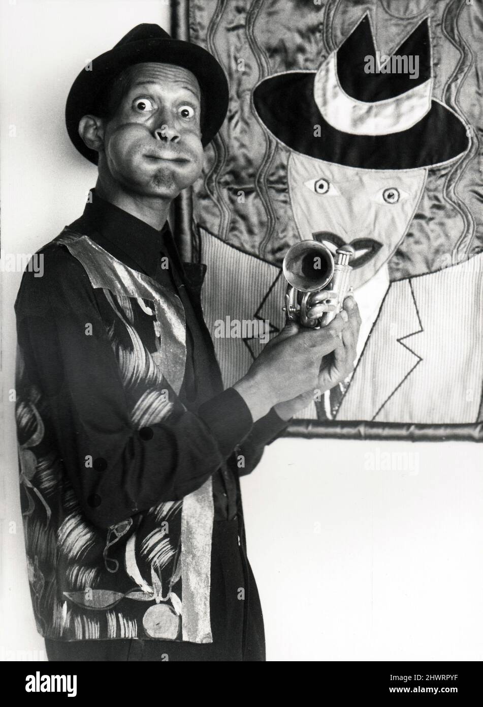 A posed portrait of the late trumpet, jazz musician and pocket trump player Don Cherry in 1983 in Brooklyn, New York. His cheeks are blown out imitating Dizzy Gillespie. I believe the artwork was a portrait of Don by his wife Moki. Stock Photo