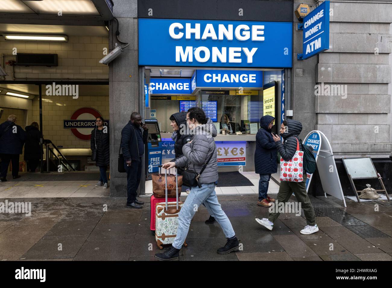 Tourists walk past a currency exchange and travel money shop along Oxford Street, London, UK Stock Photo