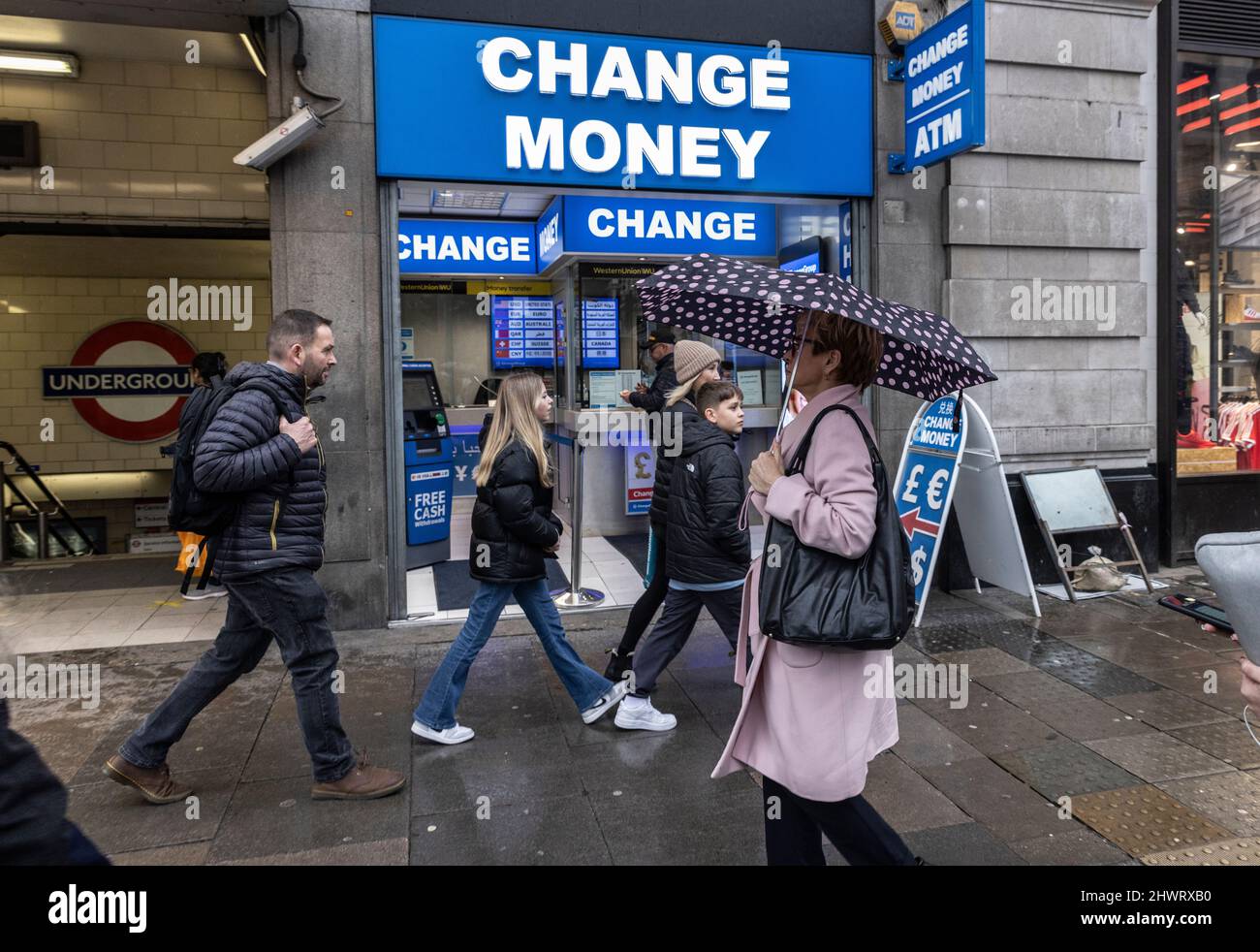 Tourists walk past a currency exchange and travel money shop along Oxford Street, London, UK Stock Photo