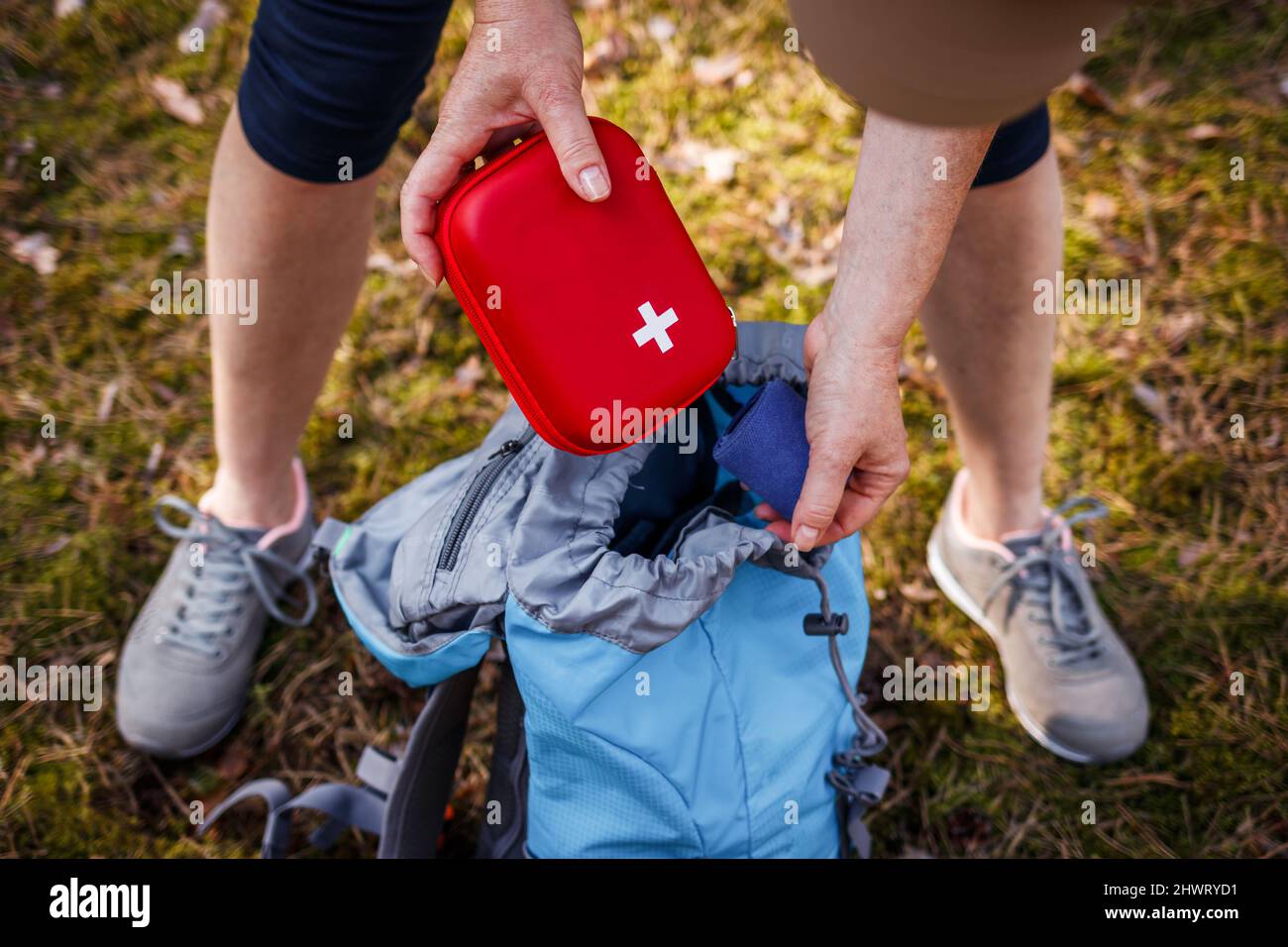 Woman taking out first aid kit from backpack. Prepared for health problems during hiking. Travel insurance for all eventualities Stock Photo