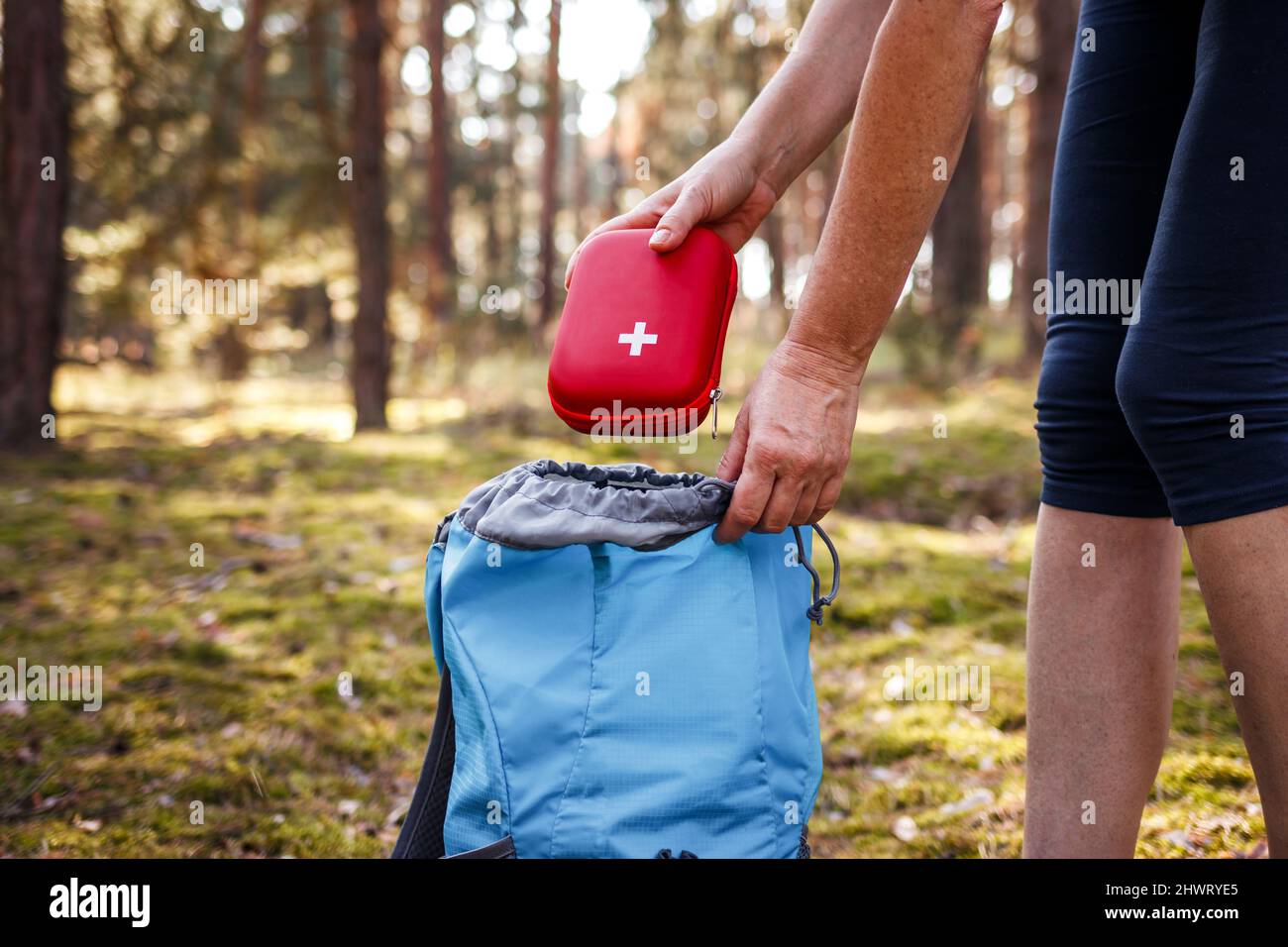 Woman taking out first aid kit from backpack. Travel insurance for all eventualities. Prepared for health problems during hiking Stock Photo
