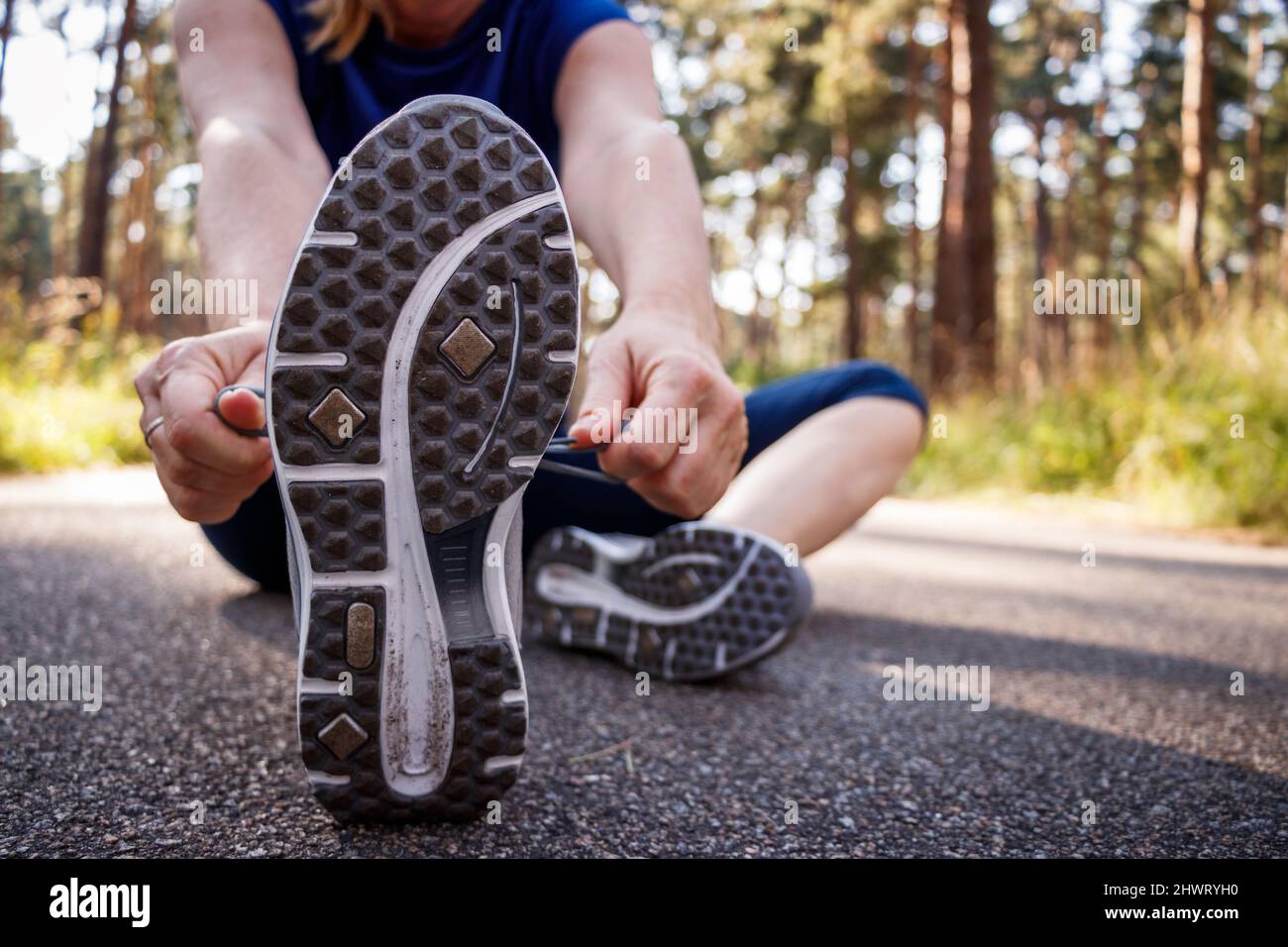 Woman tying shoelace of running shoe before jogging. Fitness and active lifestyle Stock Photo