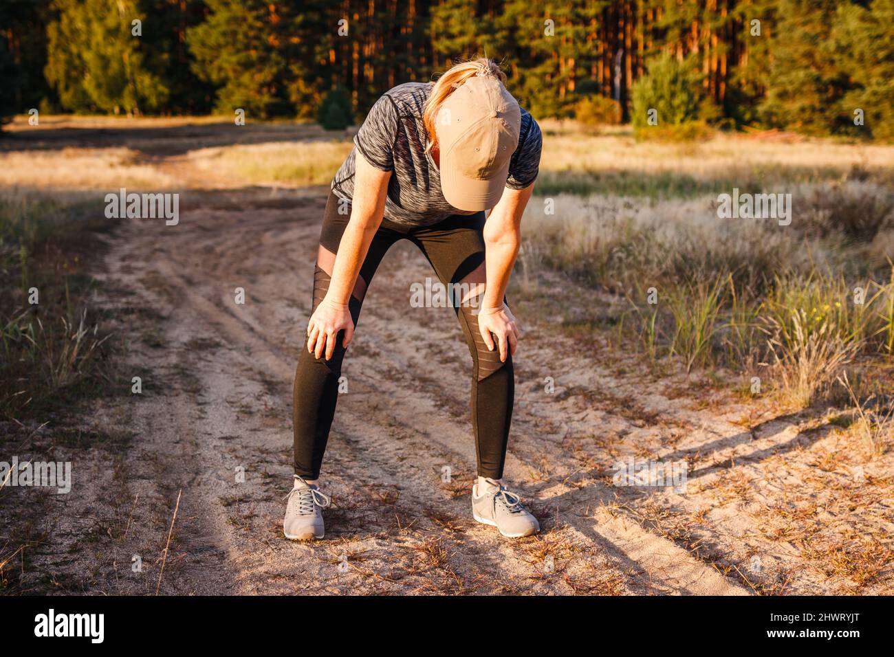 Tired woman resting after running outdoors. Female runner taking a