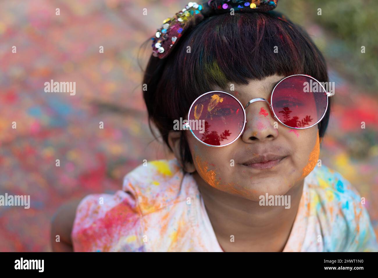 Colorful Holi Theme - Portrait Of Cute Indian Kid Wearing Round Colored Shades And Painted In Holi Color Powder Called Rang Gulal Abeer Or Abir Stock Photo