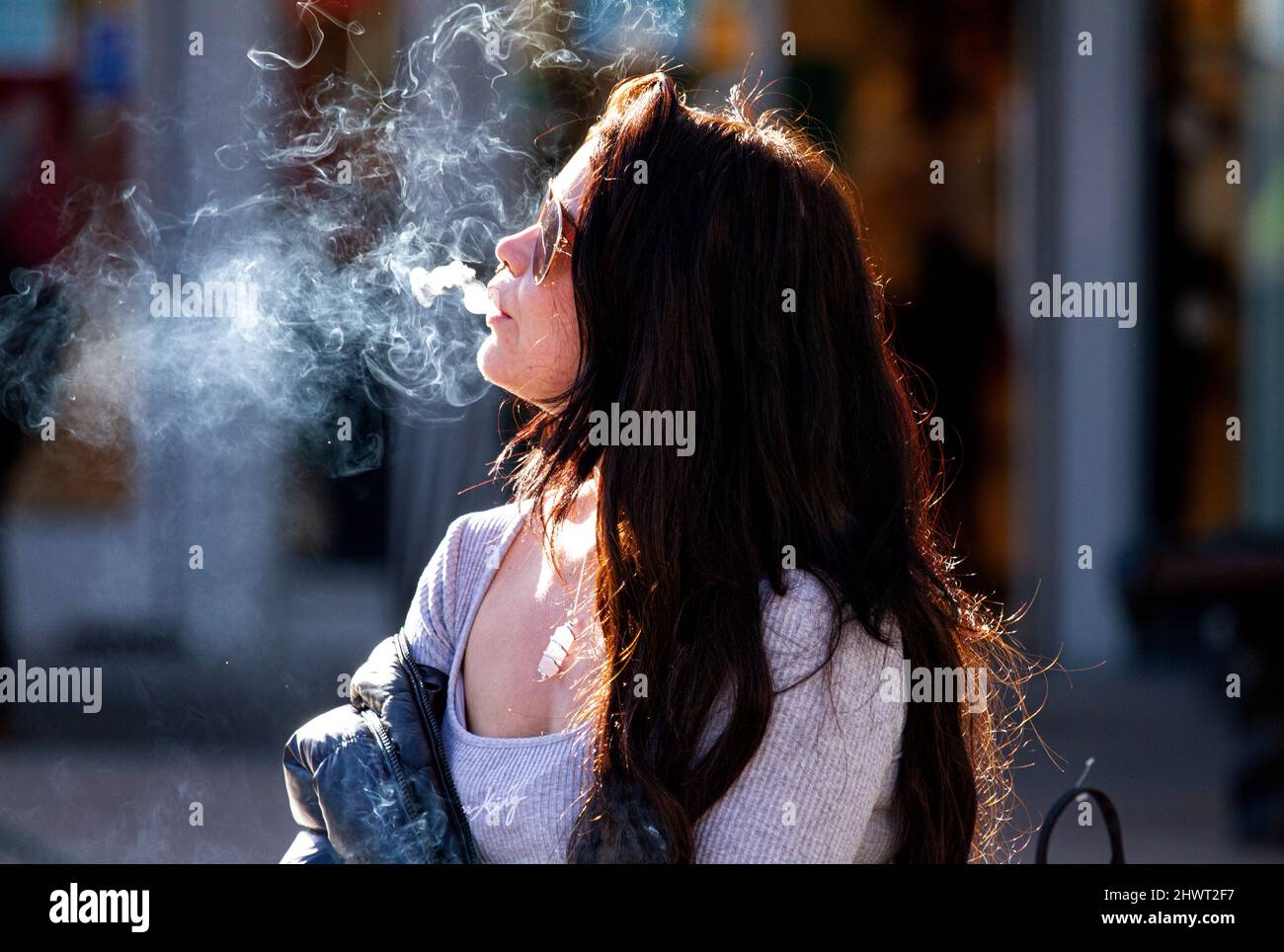 what does blowing cigarette smoke in someone's face mean Woman blowing cigarette smoke hi-res stock photography and images