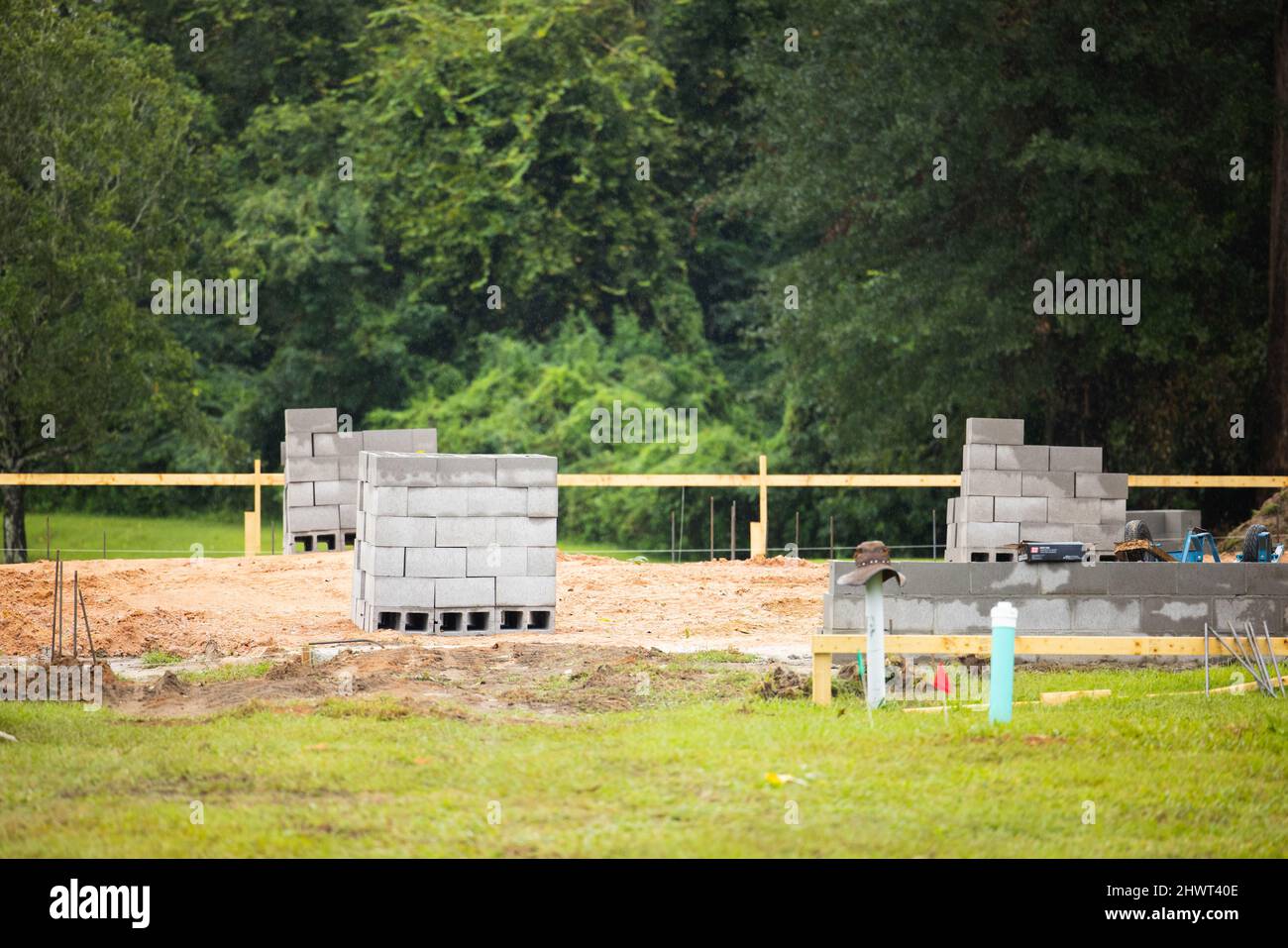 The beginning of a new construction house being built with the foundation being marked off and cinder blocks added Stock Photo