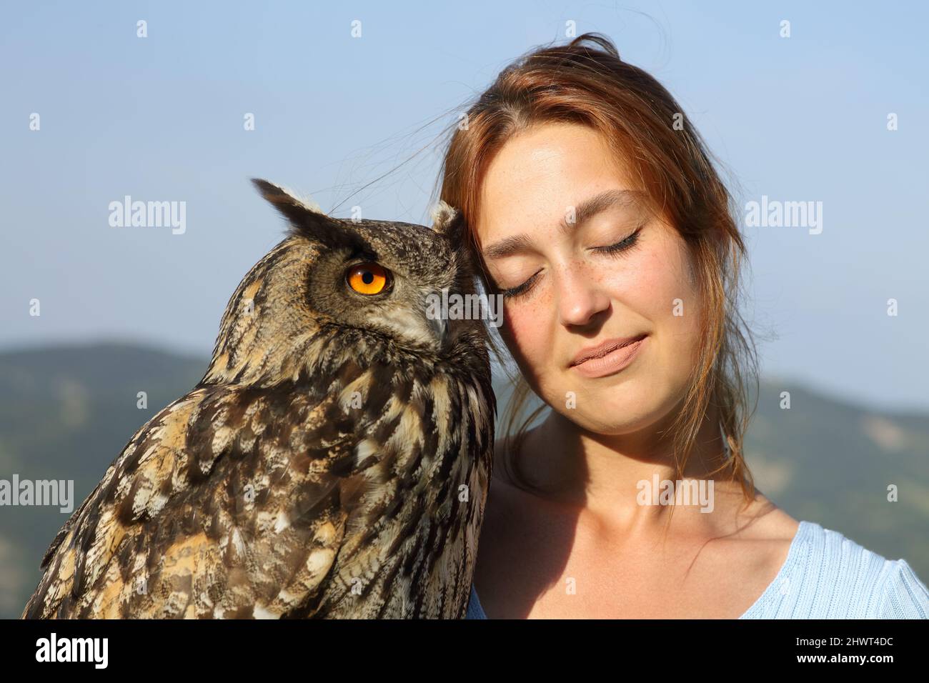 Portrait of an affectionate falconer holding an eagle owl outdoors Stock Photo