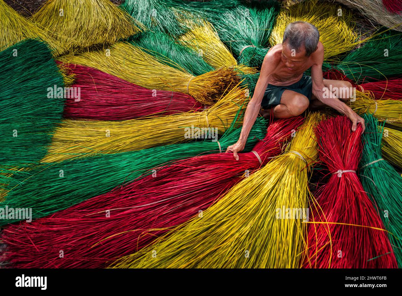 Vietnamese old man craftsman drying traditional vietnam mats in the old