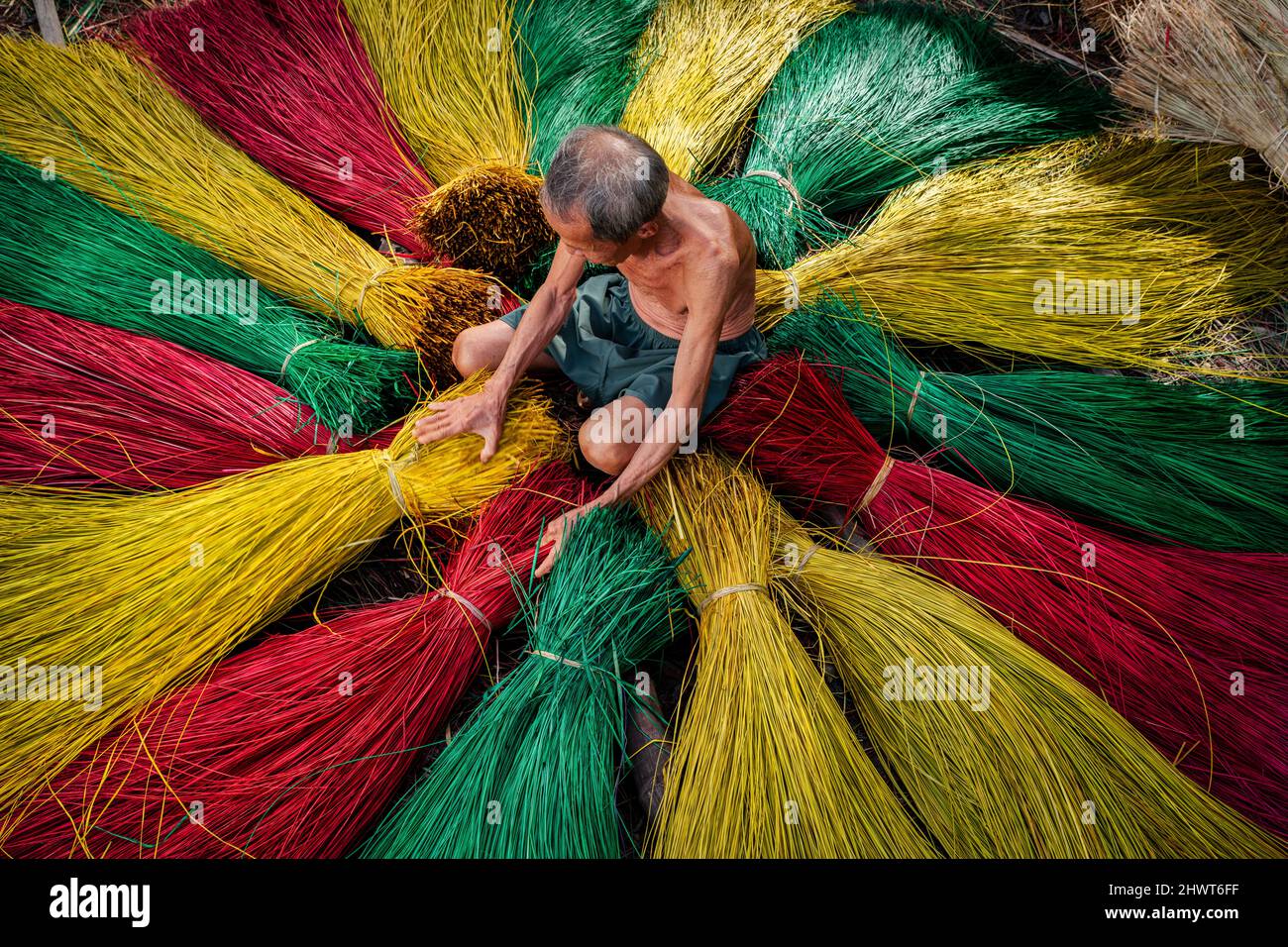 Vietnamese old man craftsman drying traditional vietnam mats in the old