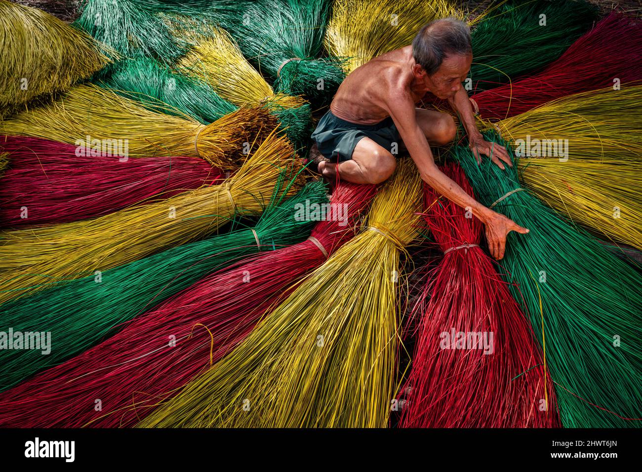 Vietnamese old man craftsman drying traditional vietnam mats in the old