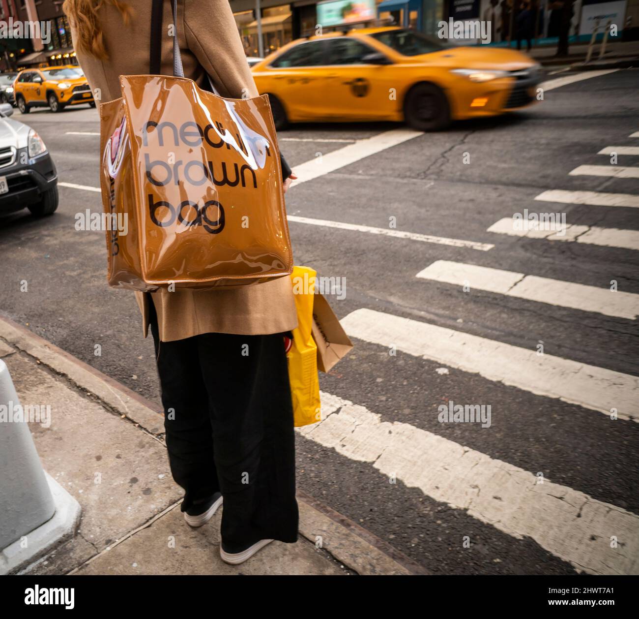 Woman with her “medium brown bag” Bloomingdale’s tote in Chelsea in New York on Friday, February 25, 2022. The tote is a facsimile of the shopping bag that the department store has used for years.  (© Richard B. Levine) Stock Photo