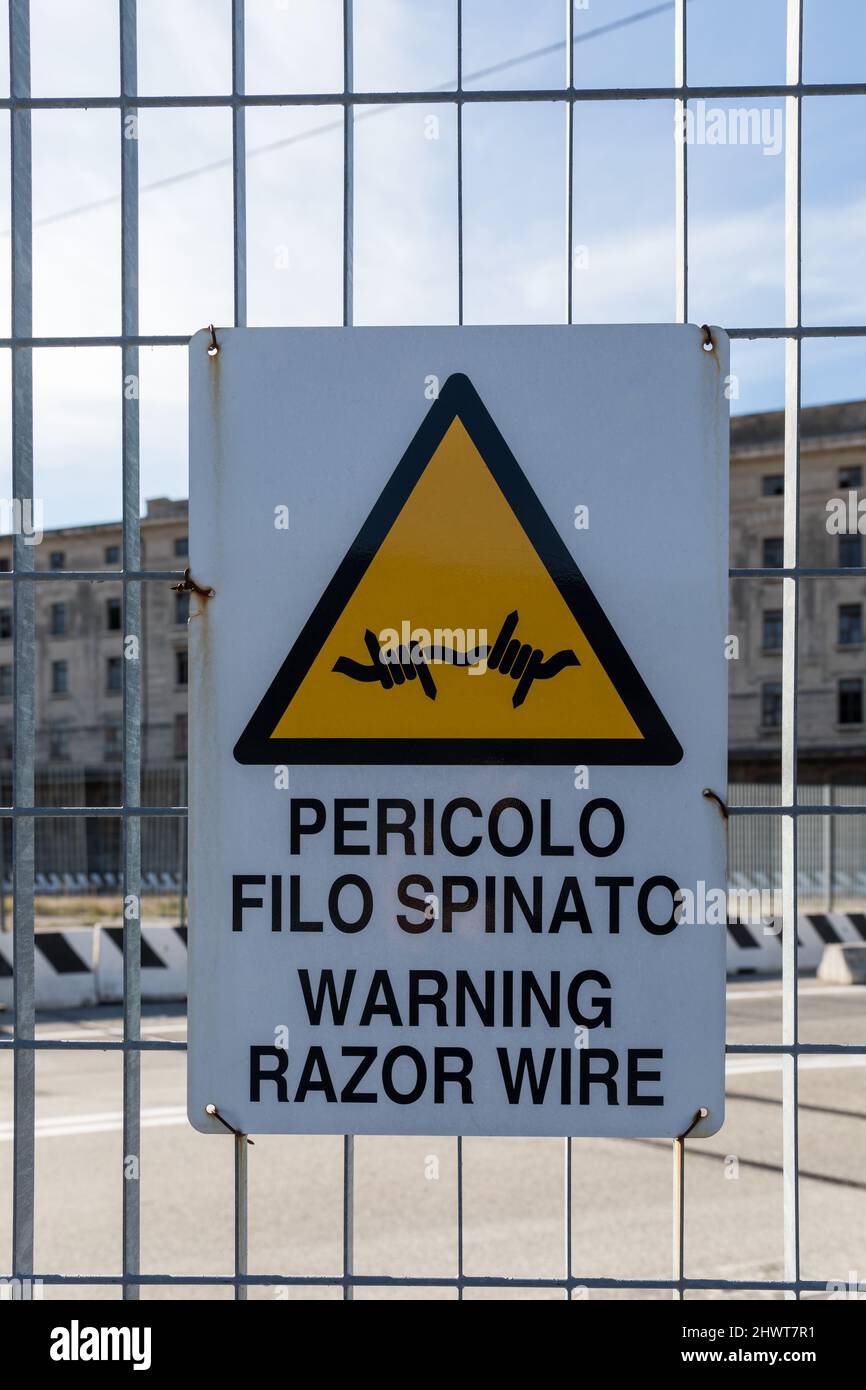 Warning razor wire sign in italian and english language Stock Photo
