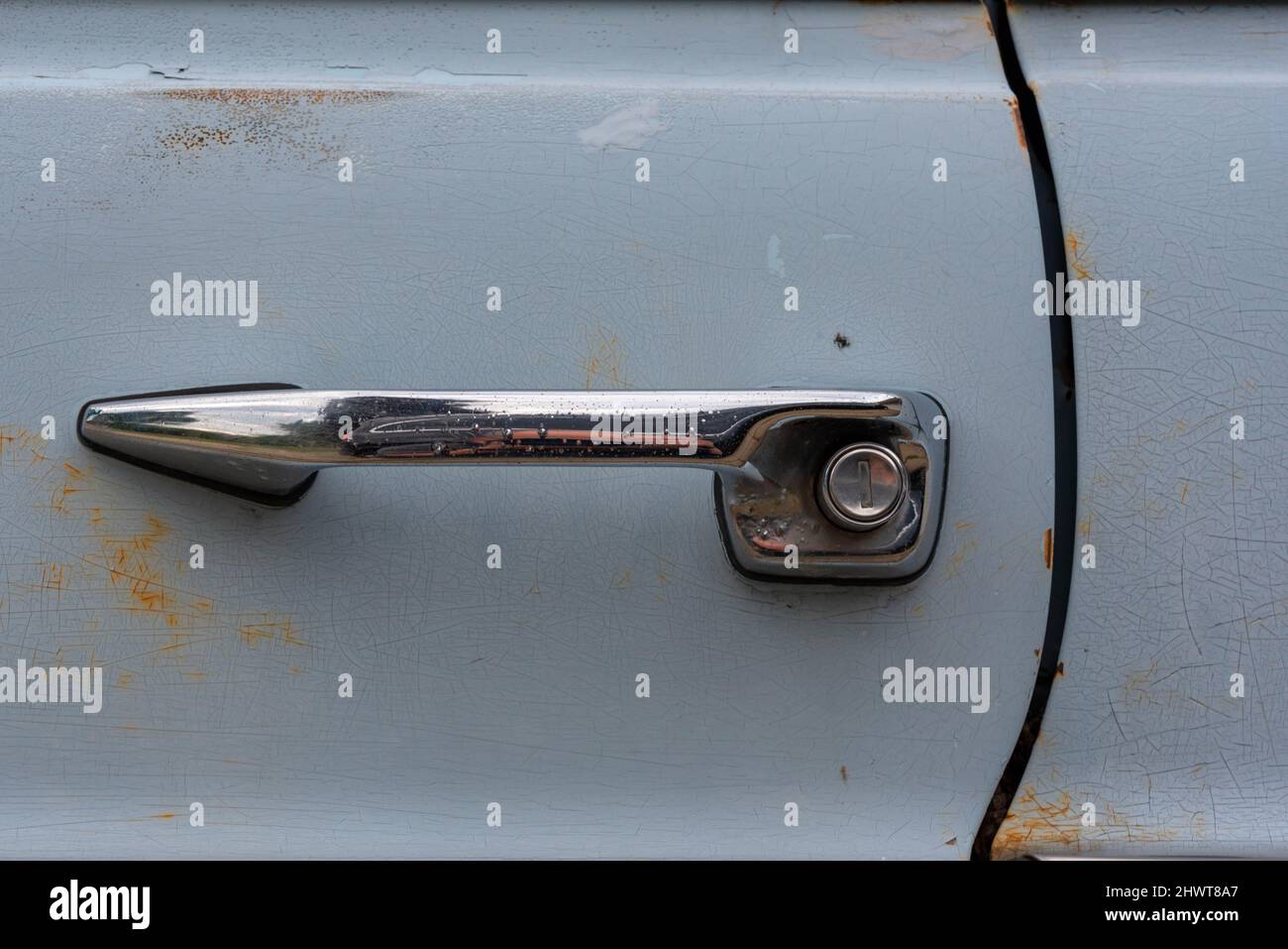 Vintage push button door styled handle on a light blue car Stock Photo