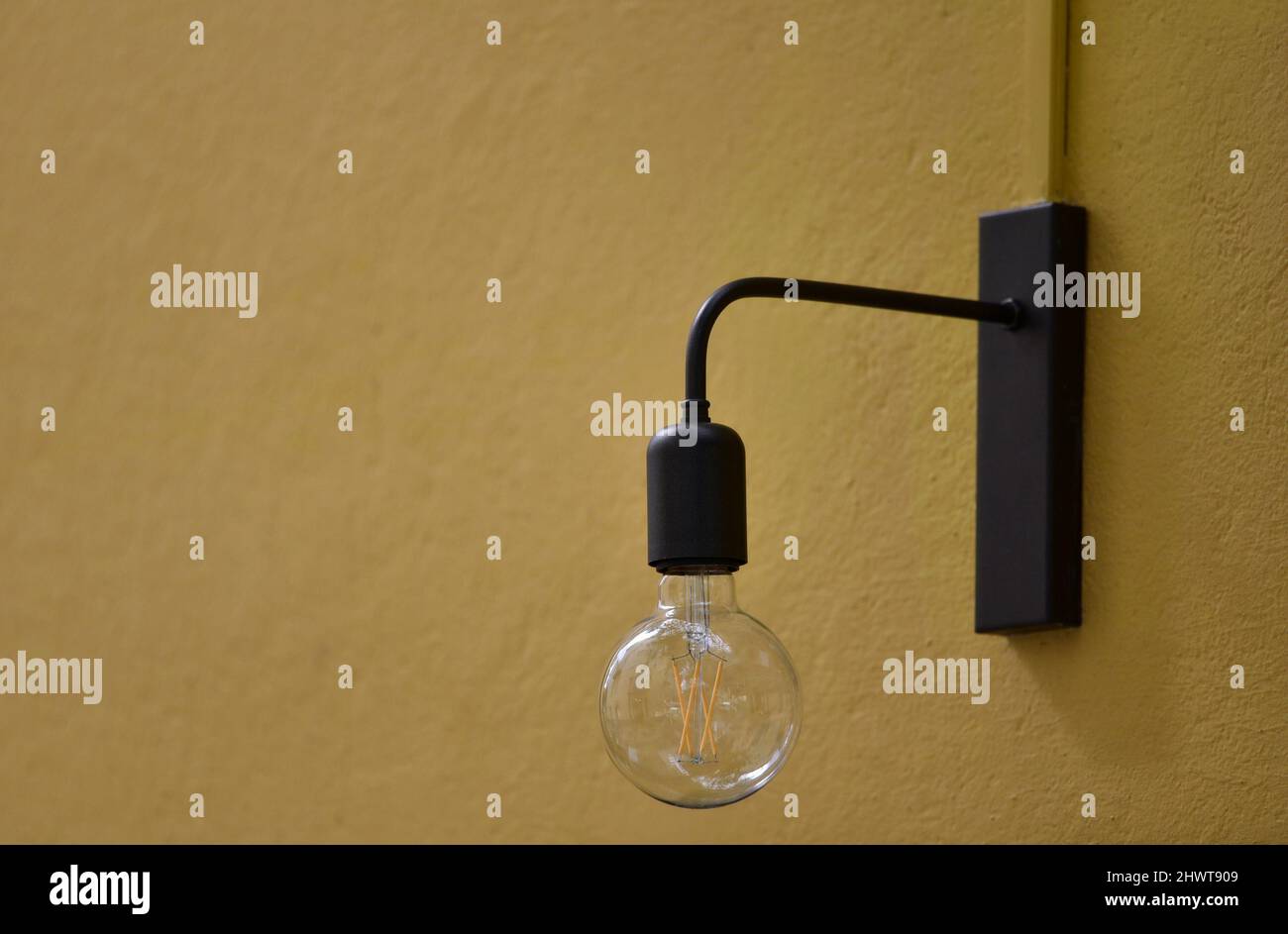Retro style cast iron wall lamp against an ochre stucco wall in Nafplio