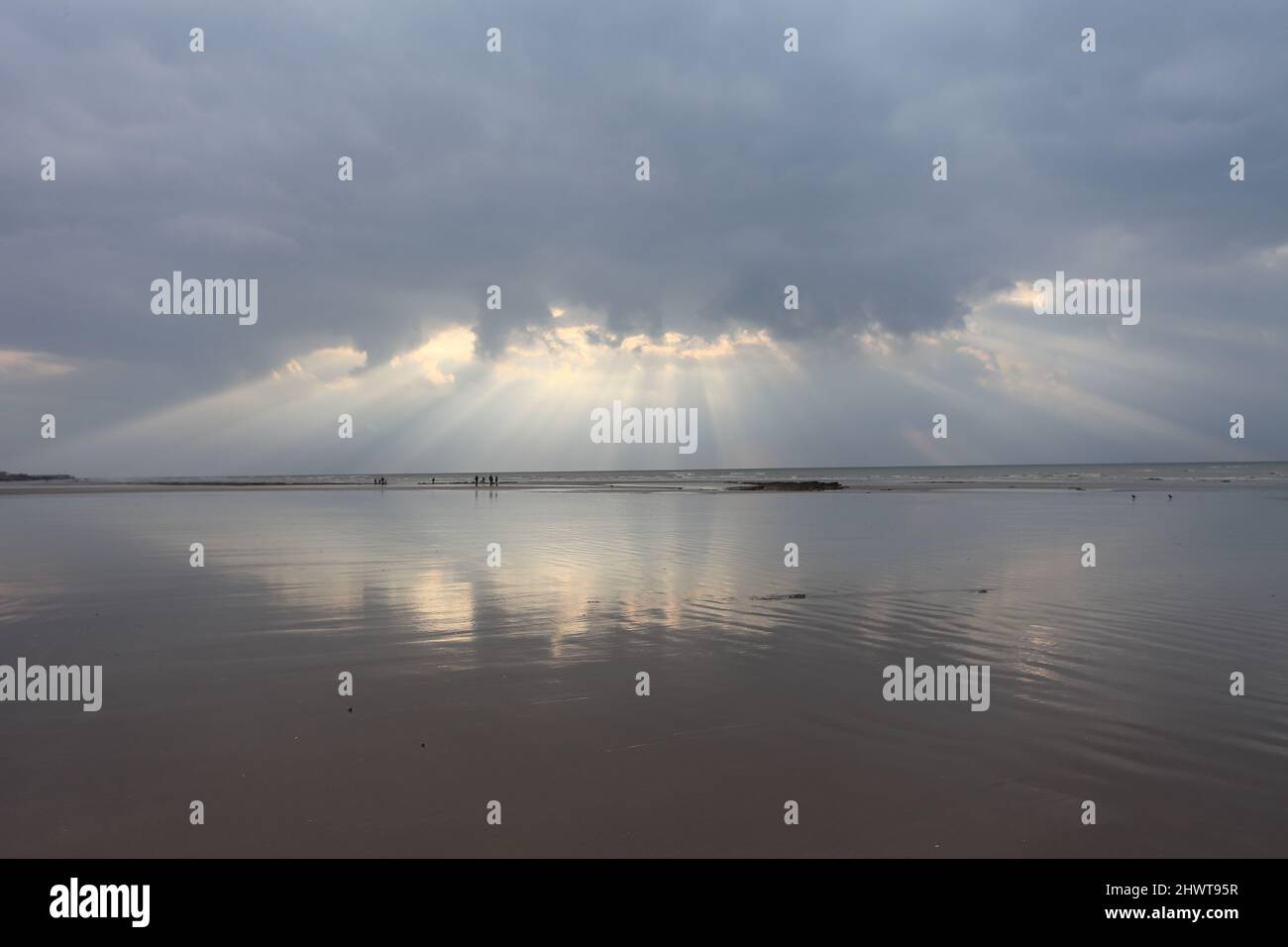 Sunrays reflected on the beach at Bulverhythe at low tide, early in the morning in winter, East Sussex, UK Stock Photo