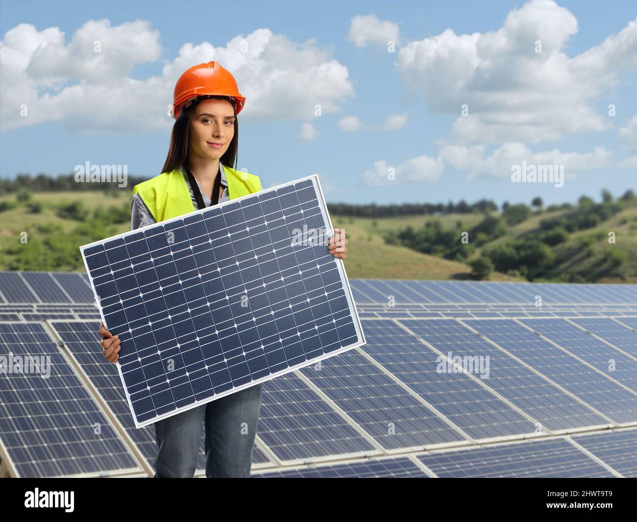 Young female engineer holding a photovoltaic solar panel on a solar ...
