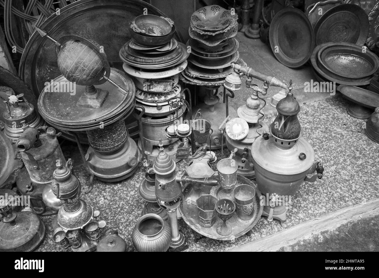 Old kitchenware (trays, teapots, coffee turks, samovars, pans, plates, cups etc) at the flea market in Old Jaffa, Israel. Black white historic photo Stock Photo