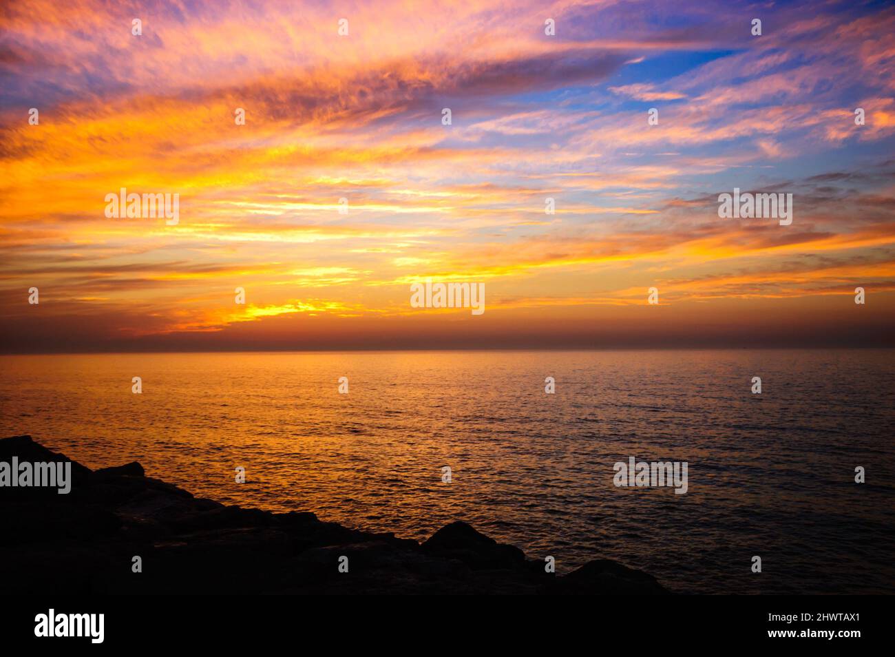 Beautiful golden sunset in the sea with saturated sky and clouds ...