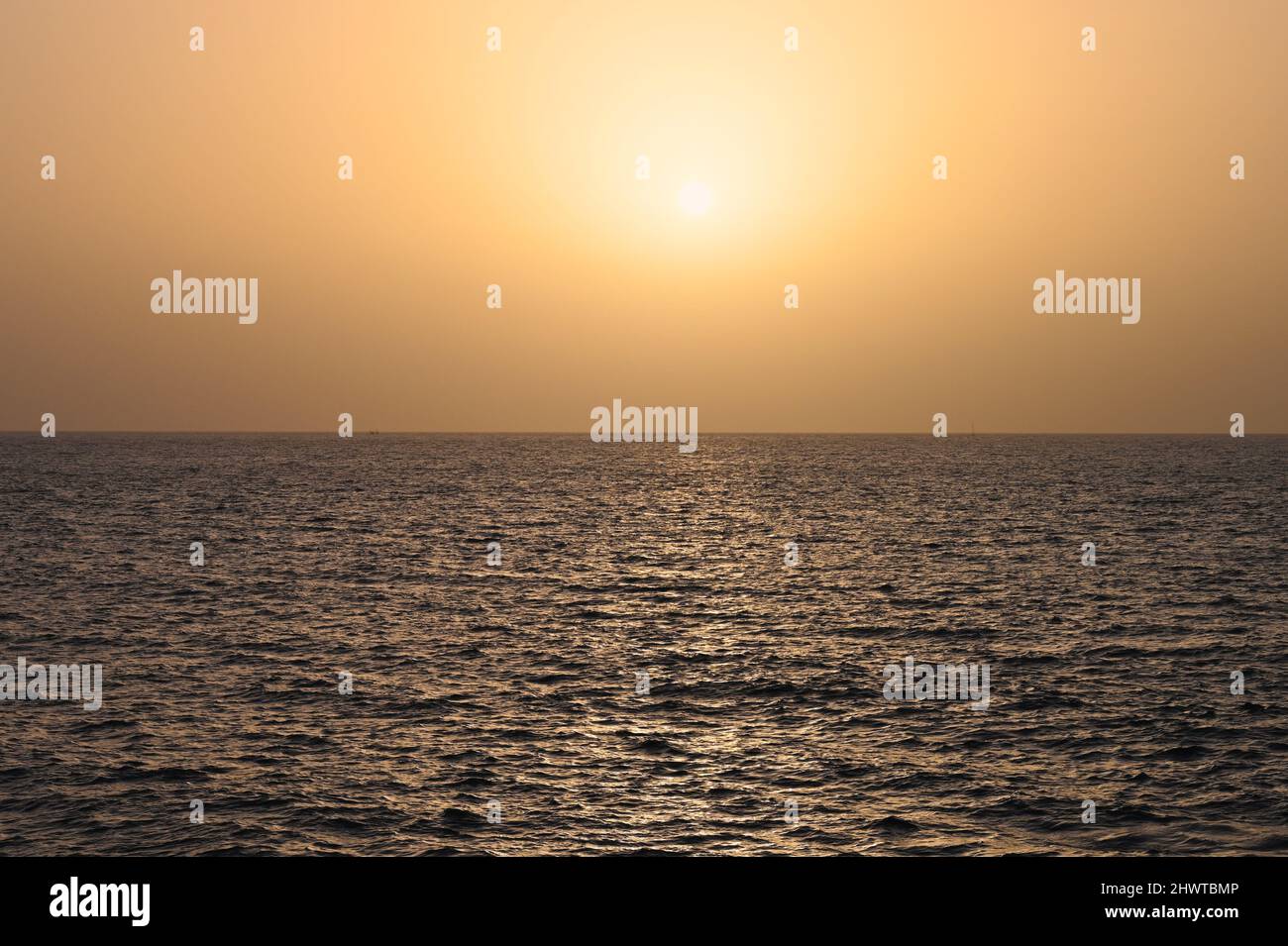 A view of the sunset over the Atlantic Ocean, in Costa Adeje, Tenerife, Spain, with the glistening beams of the sun reflecting on the ocean Stock Photo