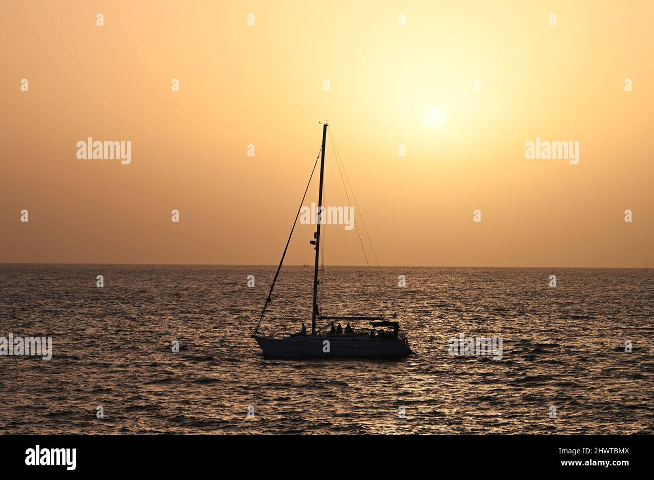 A view of the sunset over the Atlantic Ocean, in Costa Adeje, Tenerife, Spain, with the glistening beams of the sun reflecting on the ocean Stock Photo