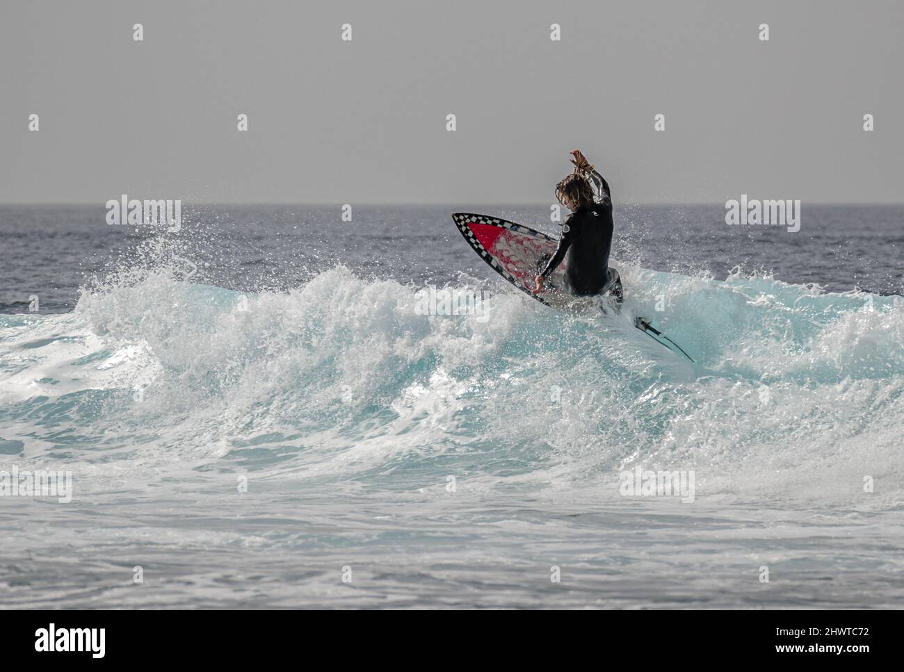 Surfers catching the waves near Playa de las Americas, Tenerife Stock Photo