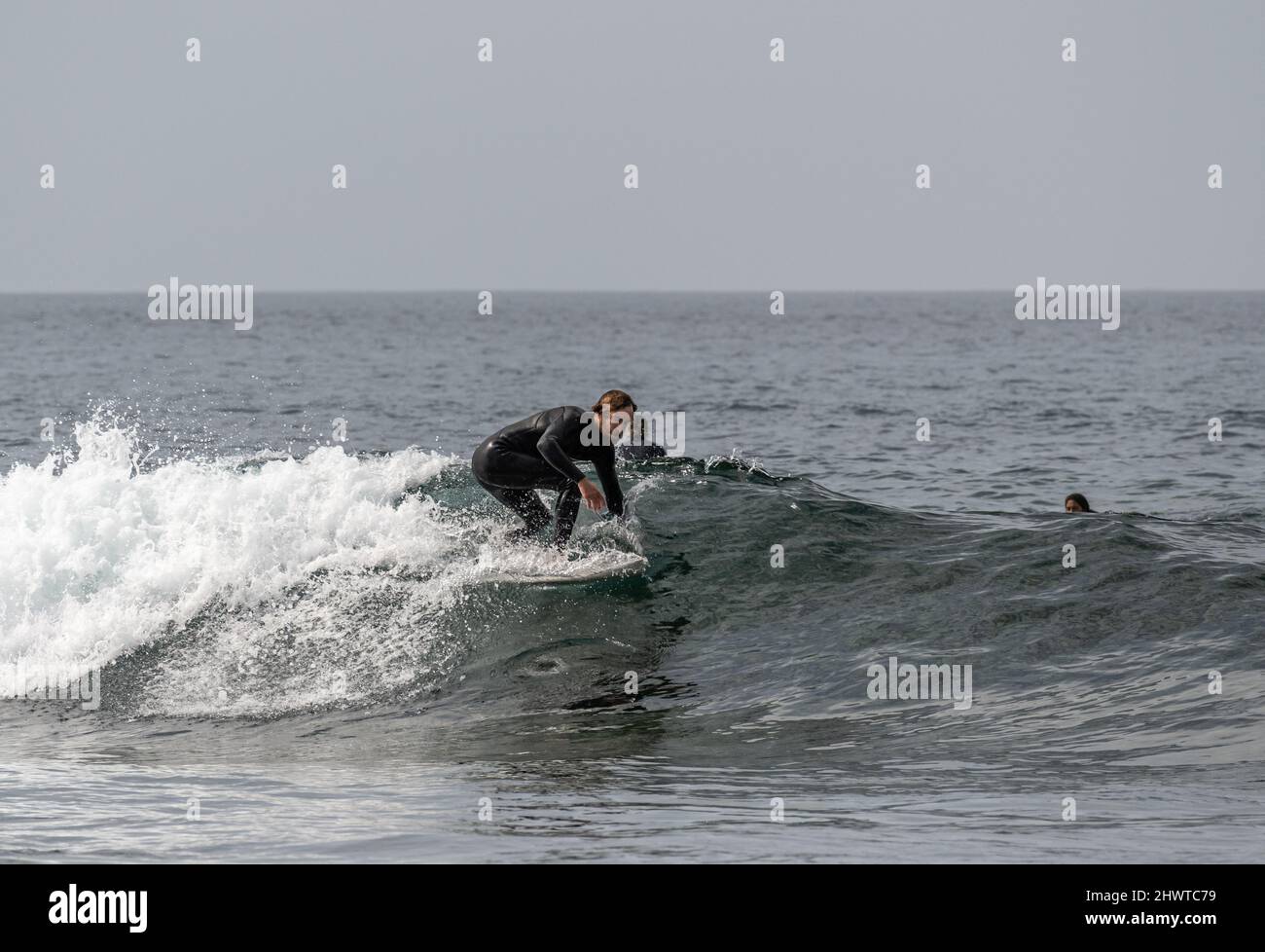 Surfers catching the waves near Playa de las Americas, Tenerife Stock Photo