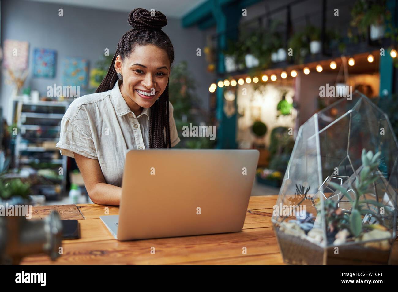 High-spirited pretty florist sitting at the laptop Stock Photo