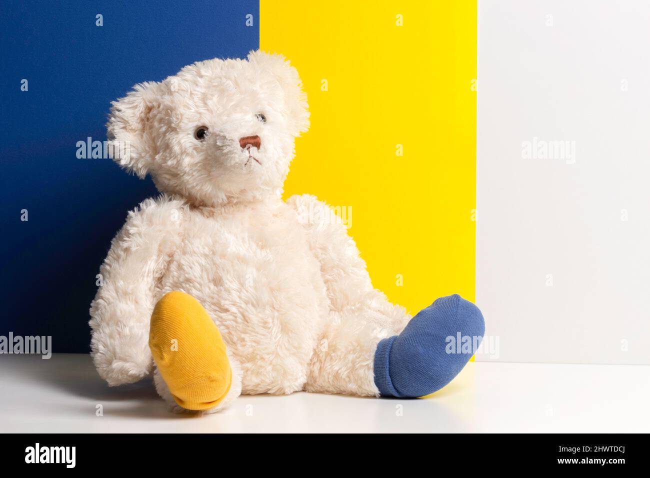 World Down Syndrome Day background. Down syndrome awareness symbol. Teddy  bear with different socks on yellow blue white background. Front view Stock  Photo - Alamy